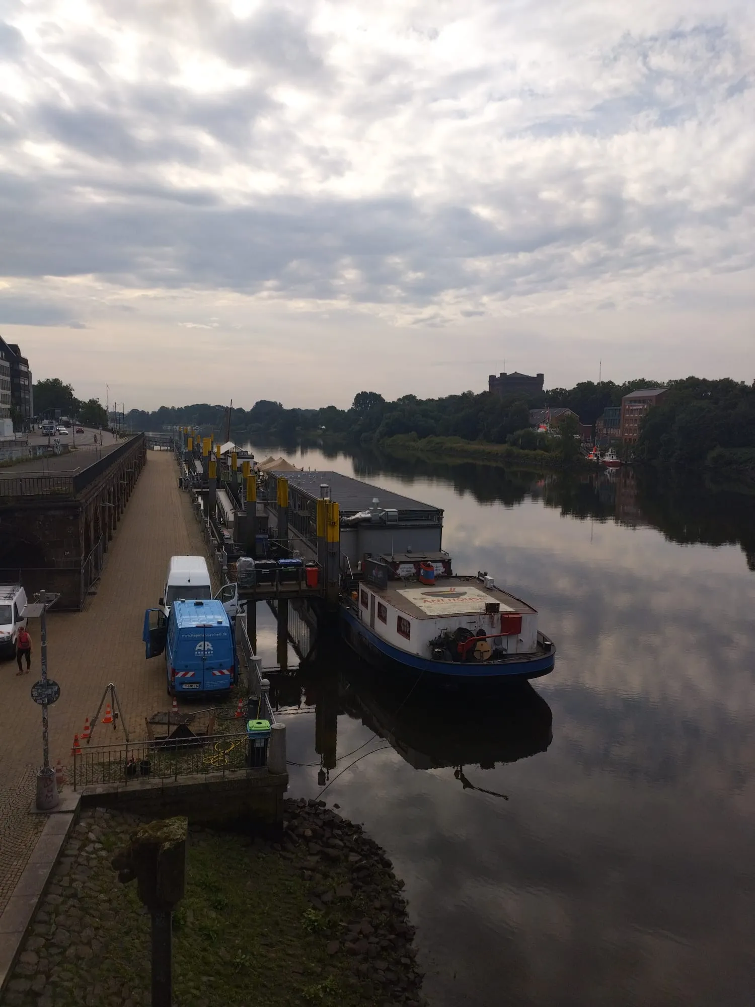 Des bateaux sont amarrés le long de la Weser à Brême sous un ciel nuageux