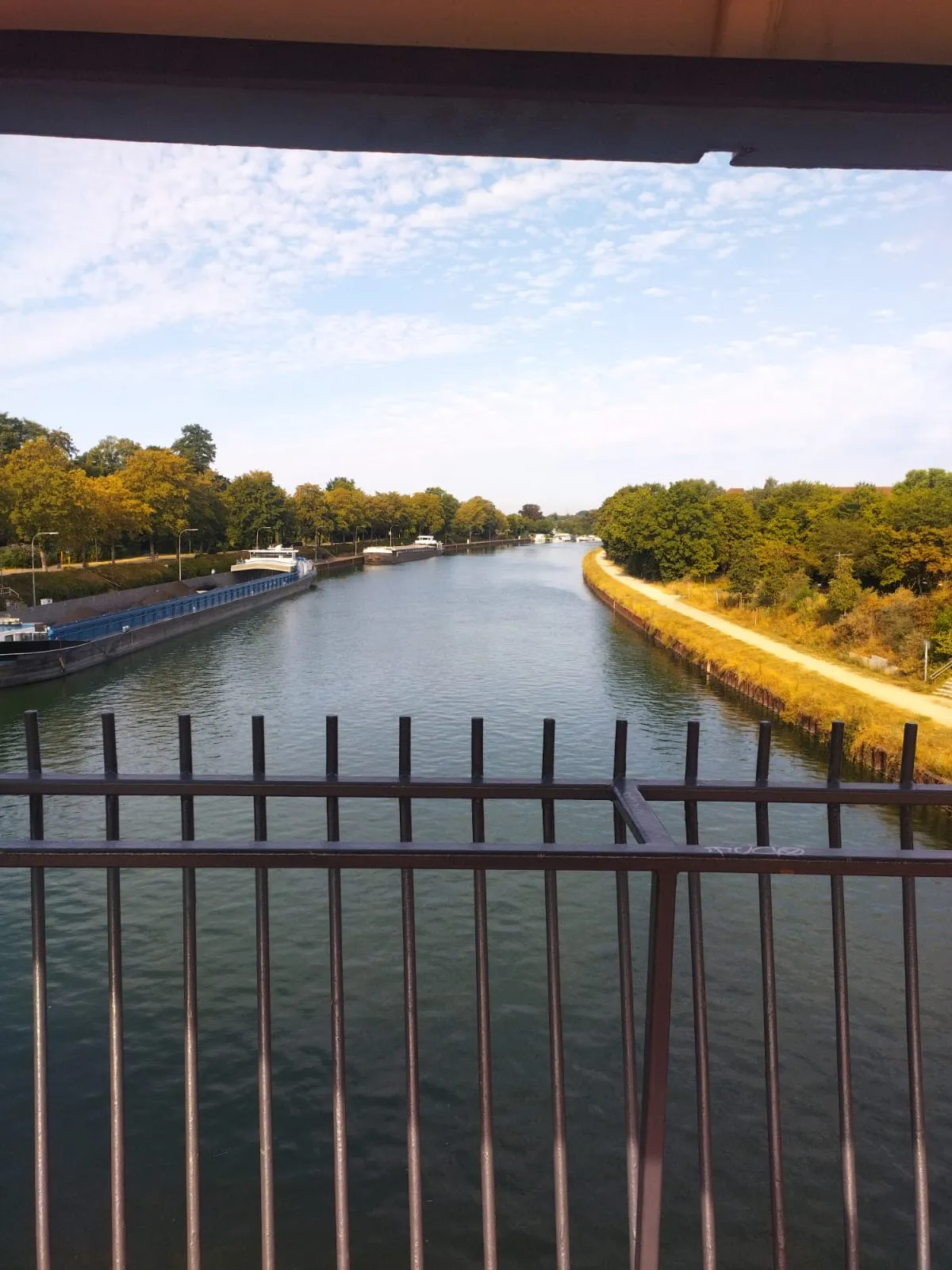 Un canal vu depuis un pont, entre les arbres et les écluses
