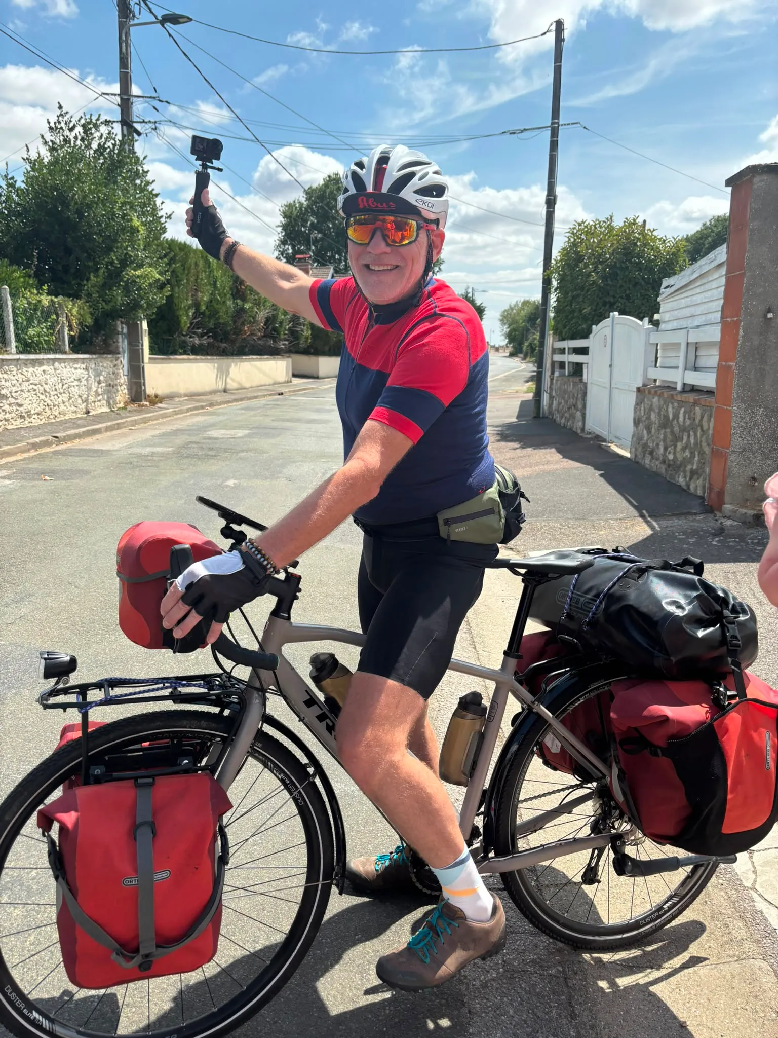 Jean-Pierre salue ses proches depuis son vélo chargé
