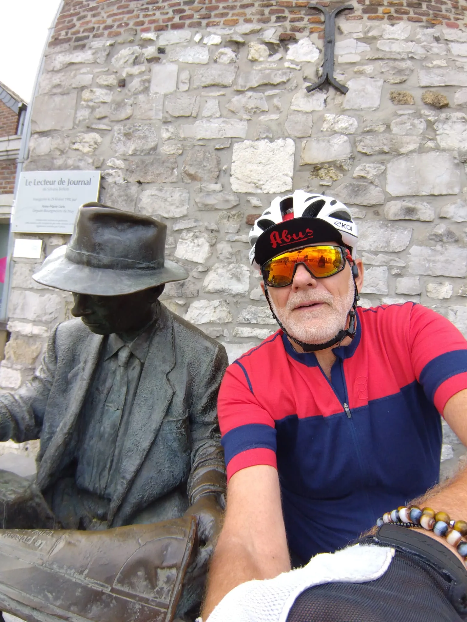 Jean-Pierre aux côtés de la sculpture Le Lecteur de Journal à Huy