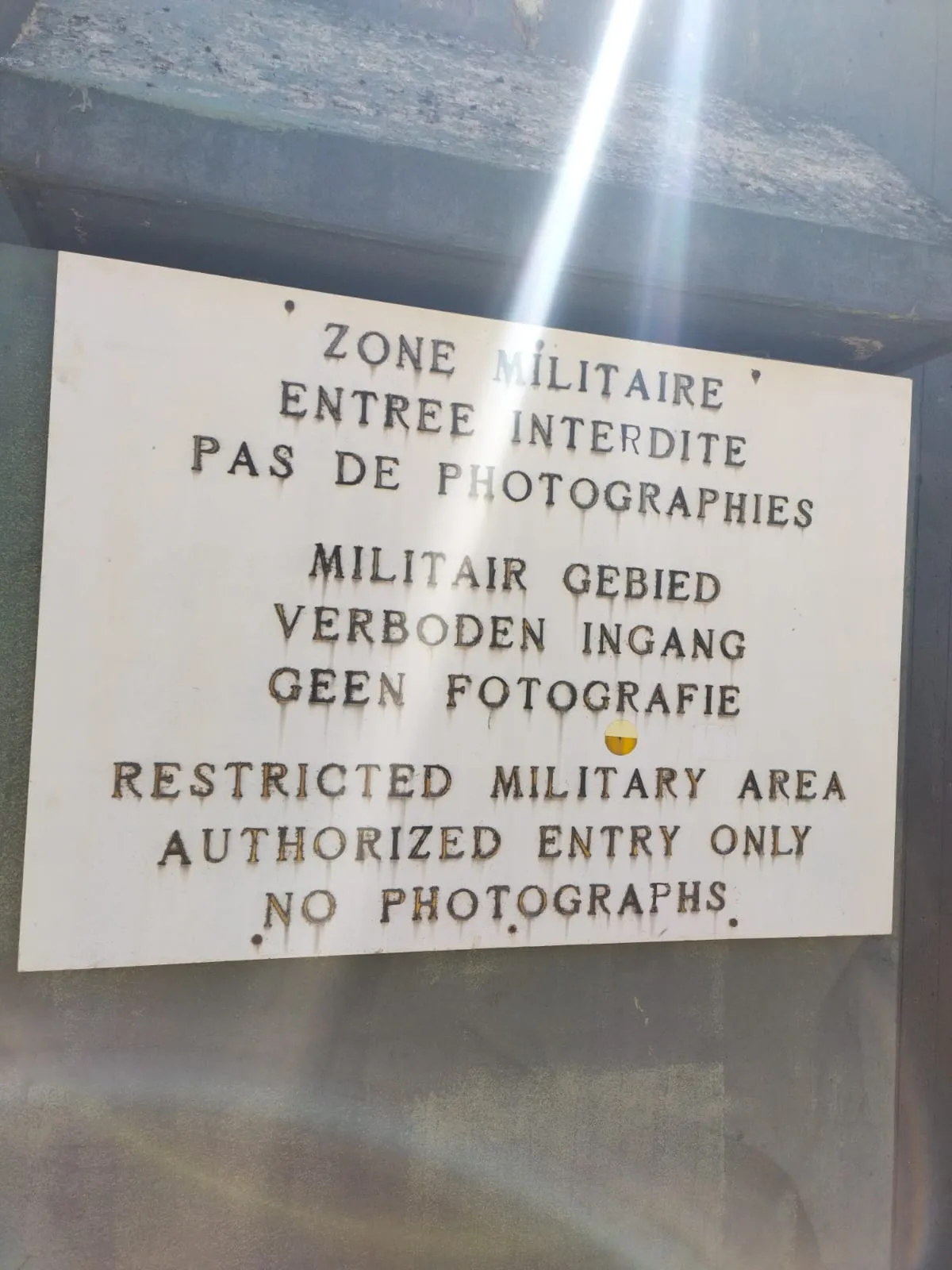 Un panneau trilingue interdisant l’entrée et les photographies dans une zone militaire