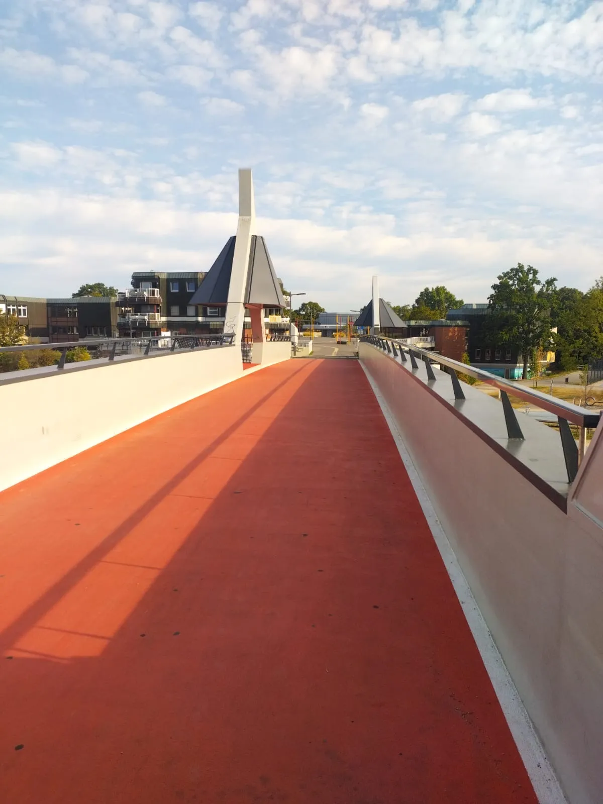 Une passerelle cyclable rouge traverse un quartier allemand