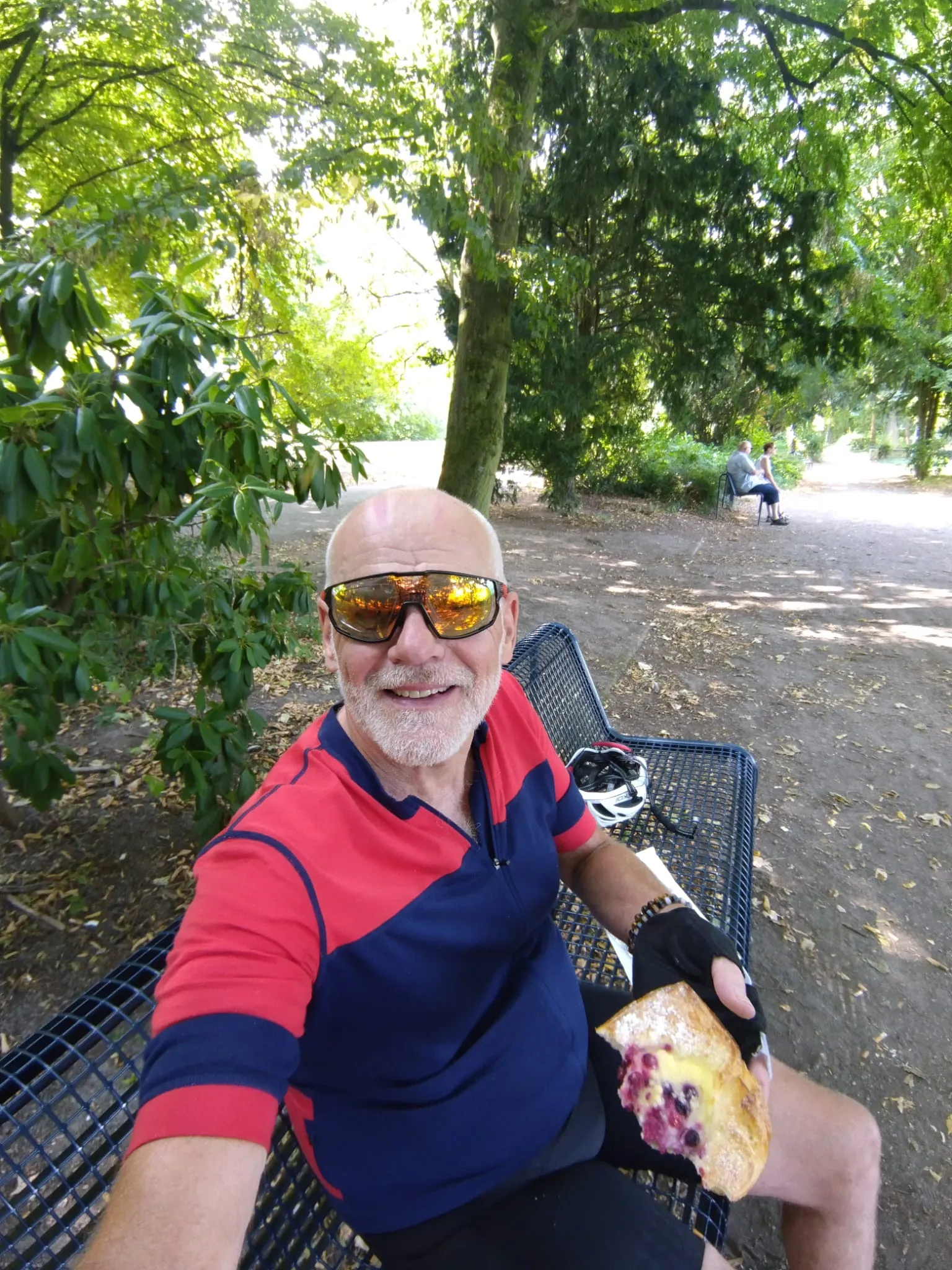 Jean-Pierre en pause sur un banc avec une part de gâteau aux fruits rouges