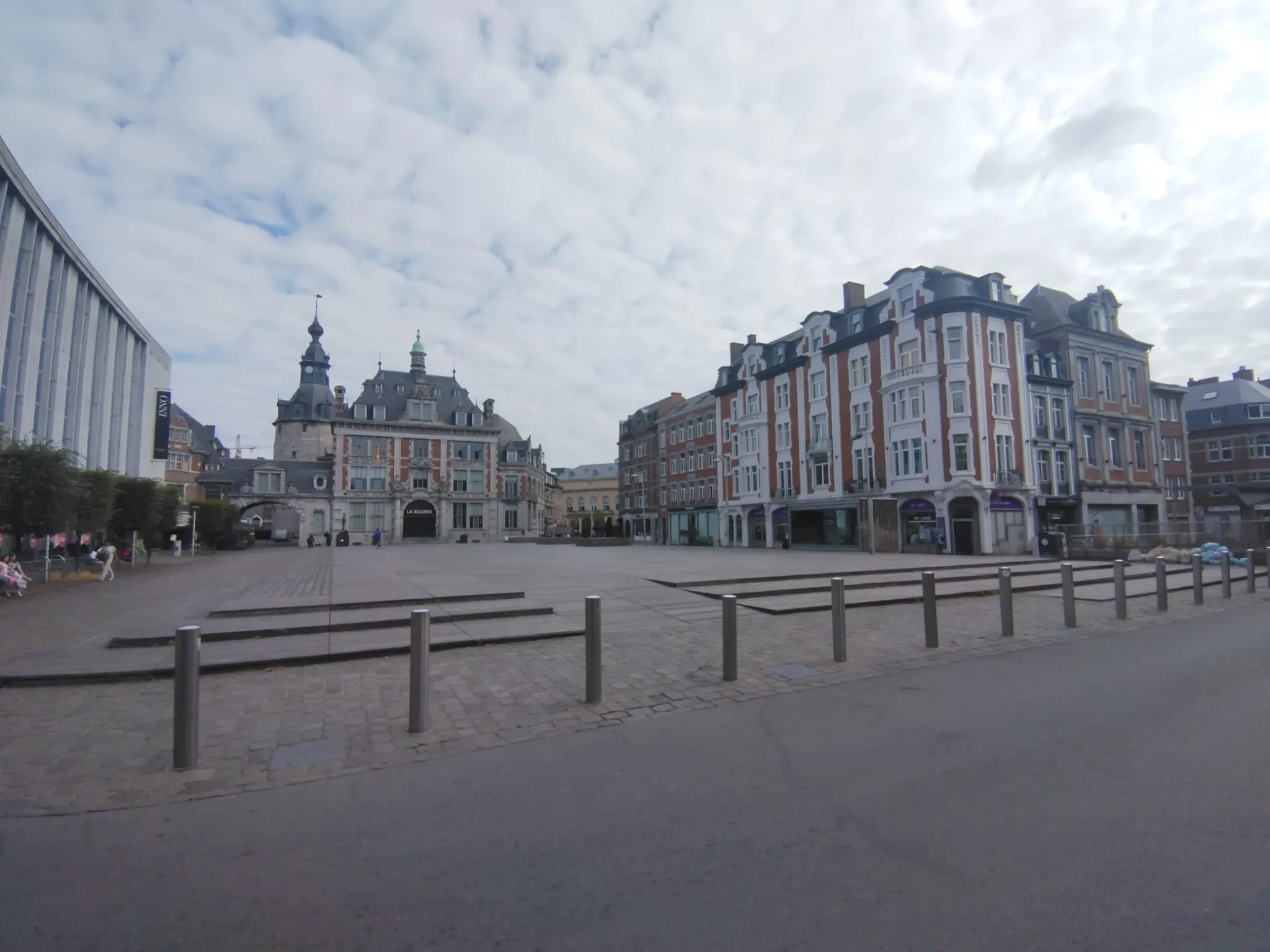 Une place de Namur bordée de bâtiments aux façades de pierre et de briques