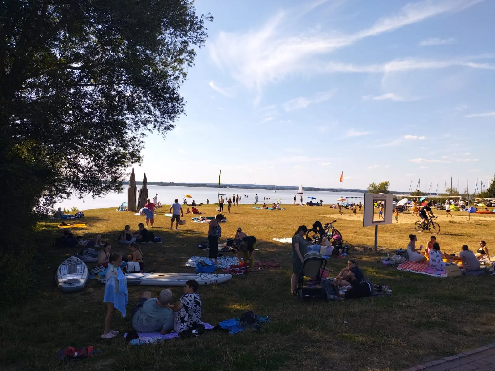 Des baigneurs et des visiteurs profitent de la rive herbeuse au bord du lac