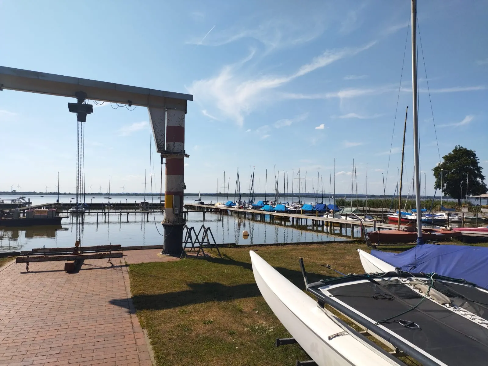 Un petit port de plaisance rassemble des dériveurs et des pontons au bord du lac