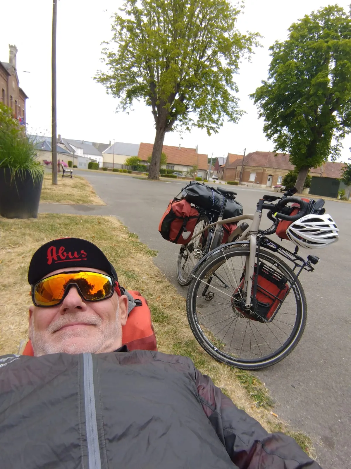 Jean-Pierre allongé près de son vélo pendant une pause au village