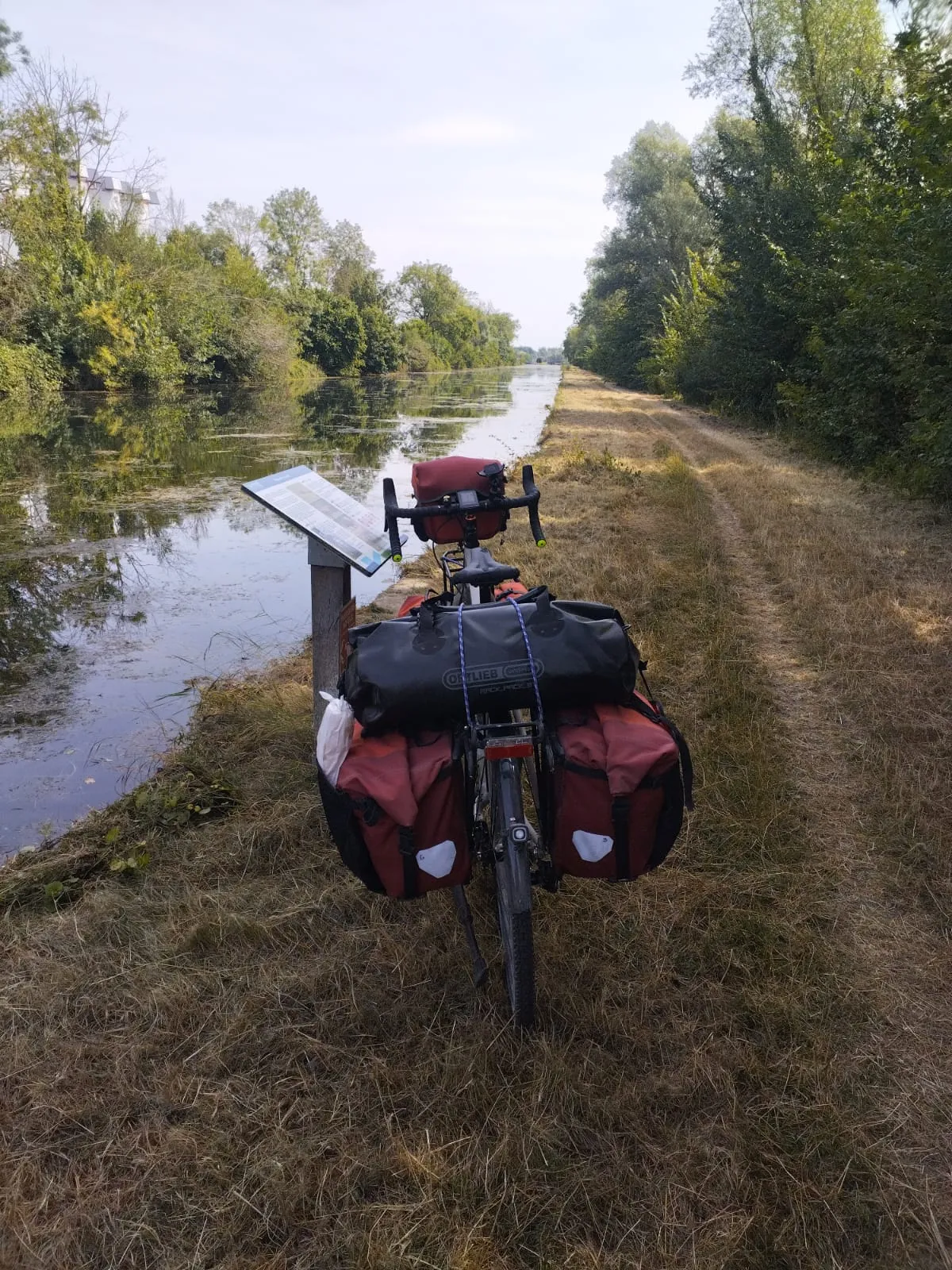 Le vélo chargé vu de dos sur le chemin de halage